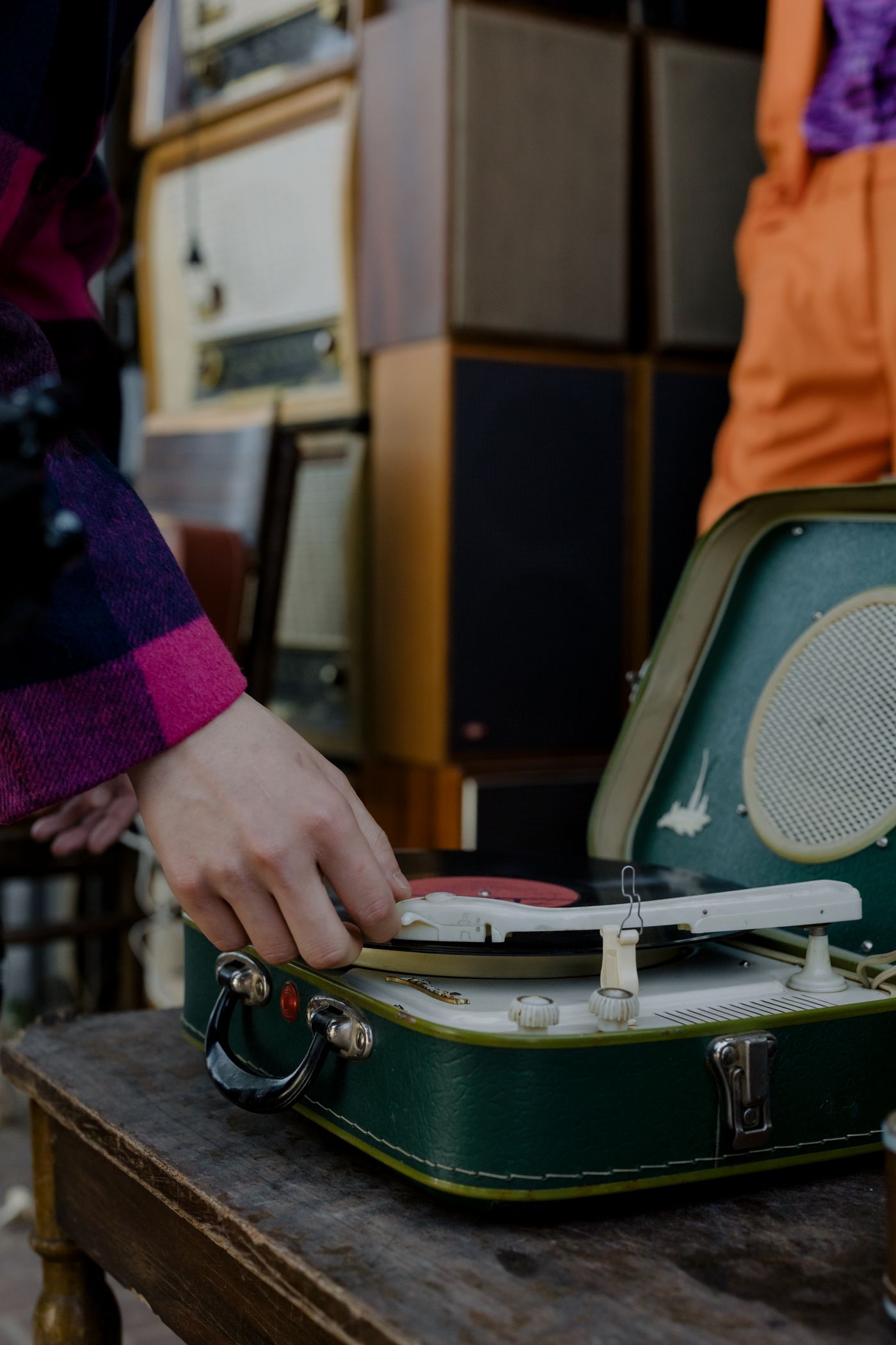 A hand using the controls of a portable record player