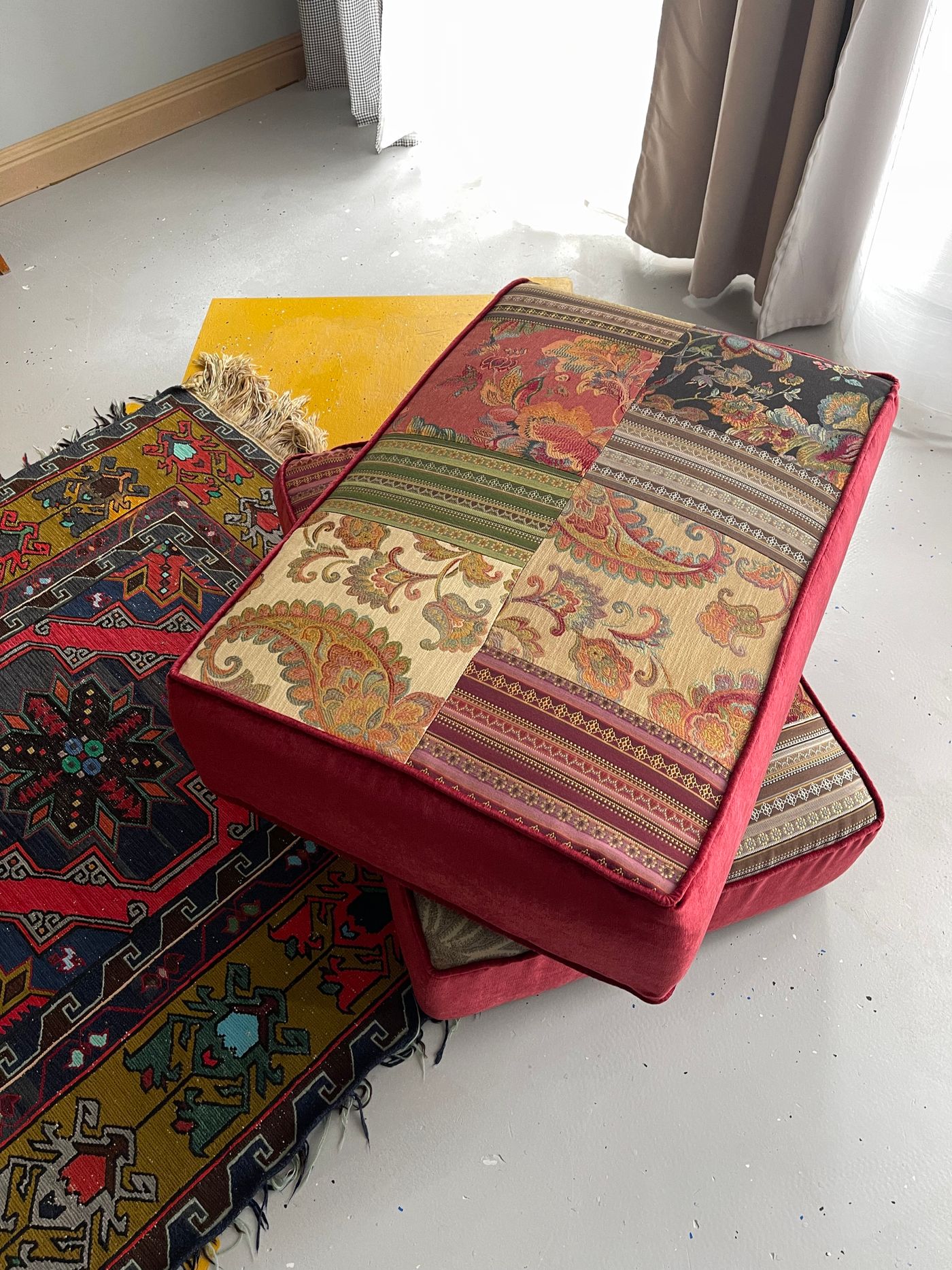 Layered patterned cushions resting on a floor
