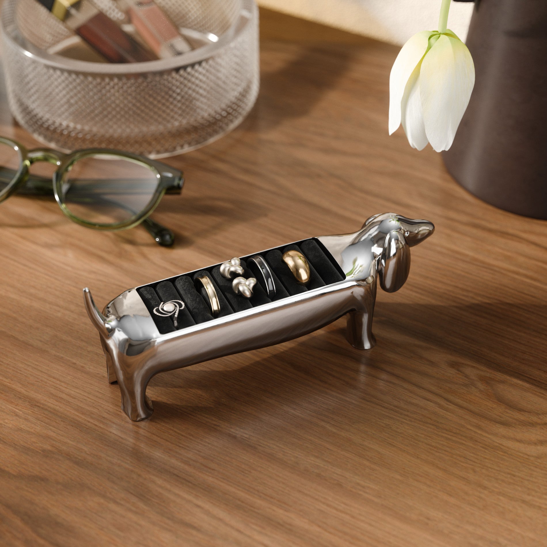 Chrome Umbra Dachsie ring holder beside glasses and a flower