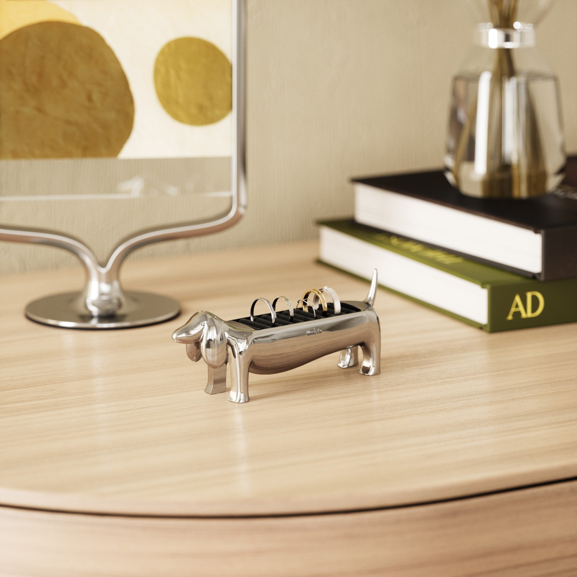 Chrome Umbra Dachsie ring holder on a round dresser top